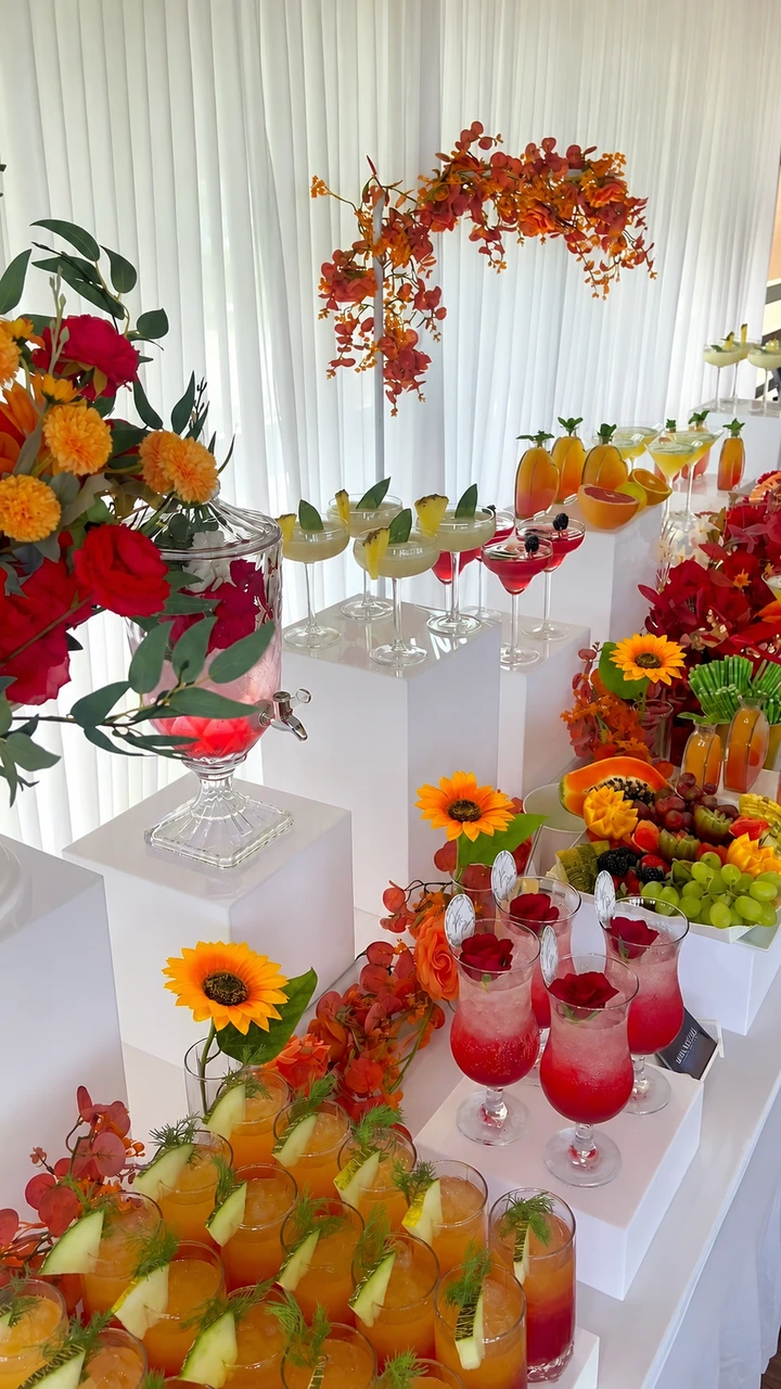 An autumn-inspired drinks display with fruit and floral styling