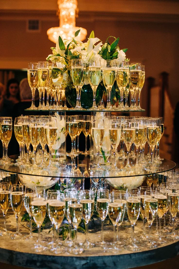 A formal champagne display arranged around white flowers