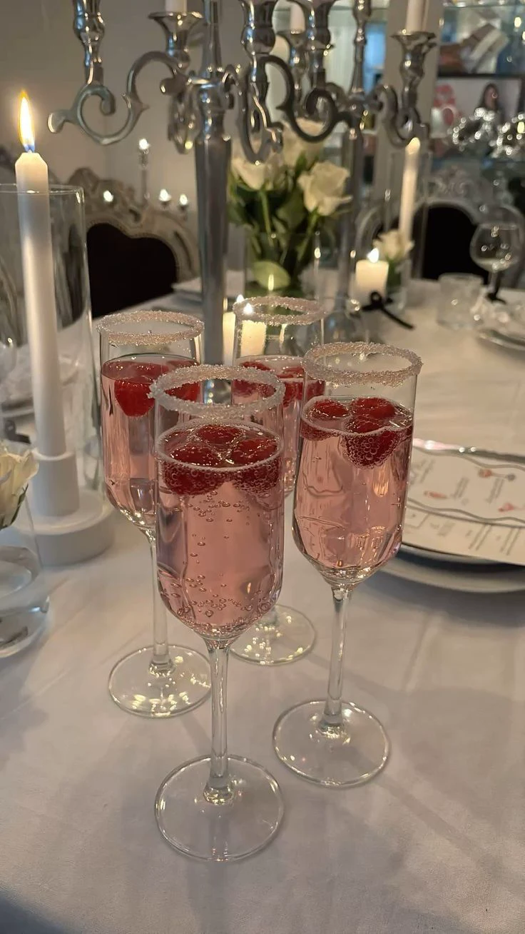 Raspberry fizz glasses on an elegant candlelit table