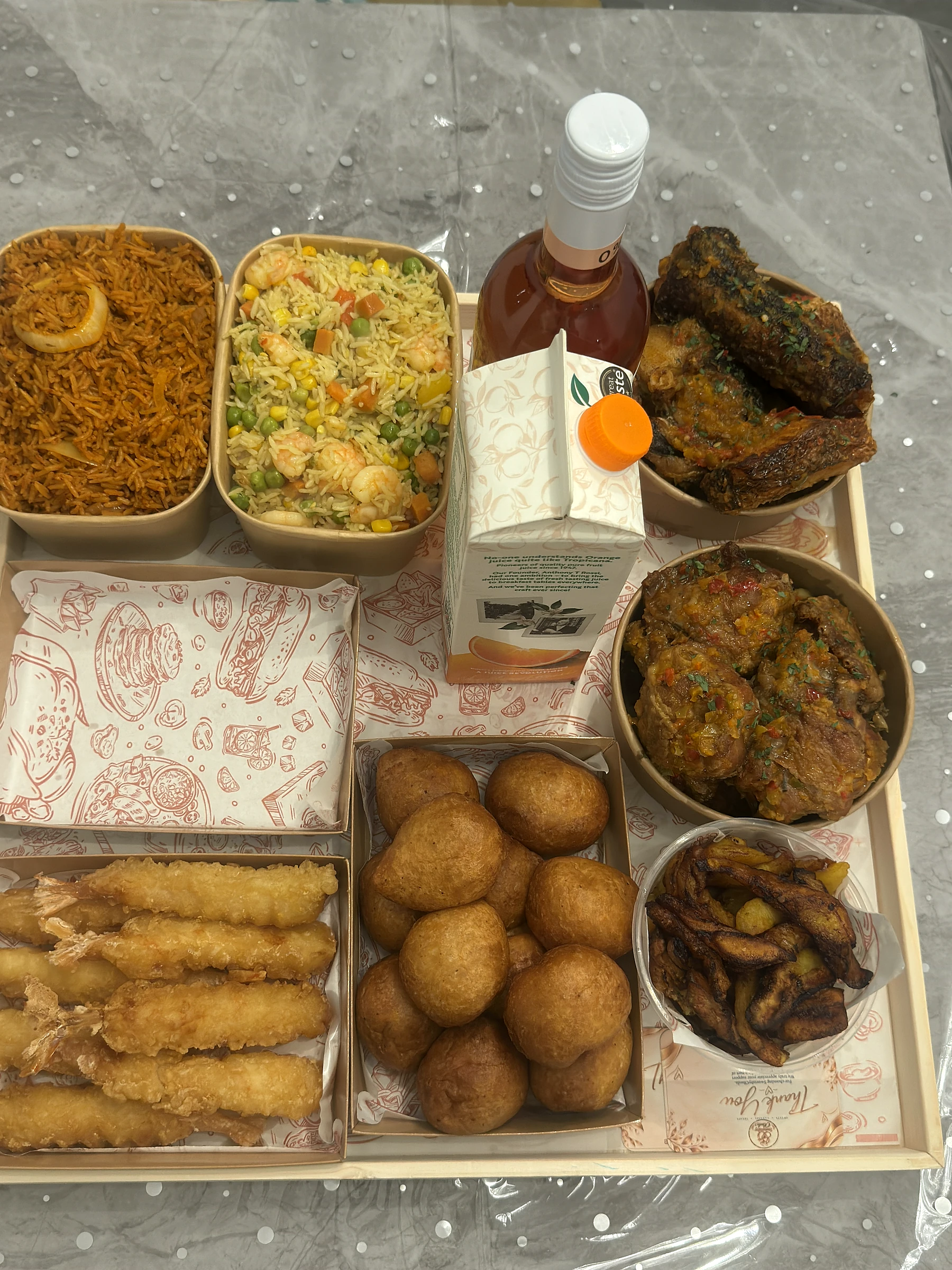 A generous celebration feast with rice, seafood, meats, plantain and puff-puff
